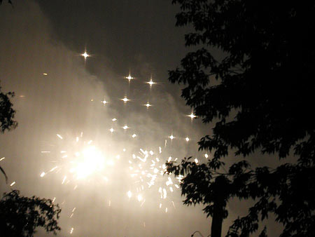 hazy fireworks, seen through the window screen