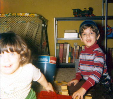 Tommy sharing toys with preschool aged little sis while she lunges at the photographer