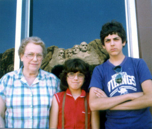 Sister Sharyn, Tom, and grandma Viv posing under a reflection of Mount Rushmore