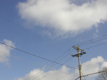 powerlines and blue sky with puffy white clouds